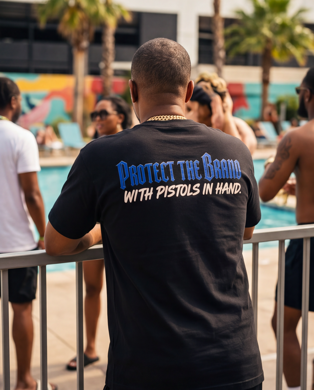 Back view of a model styling an oversized XL black heavyweight graphic t-shirt in an urban street setting.